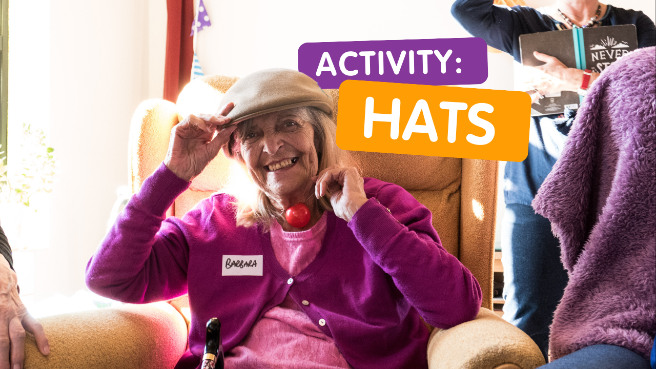 An elderly white woman places a hat on her head and smiles. Words read 'activity: hats'